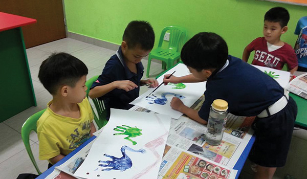 Members of 1st Kuala Lumpar Company trying out hand painting with their younger members.